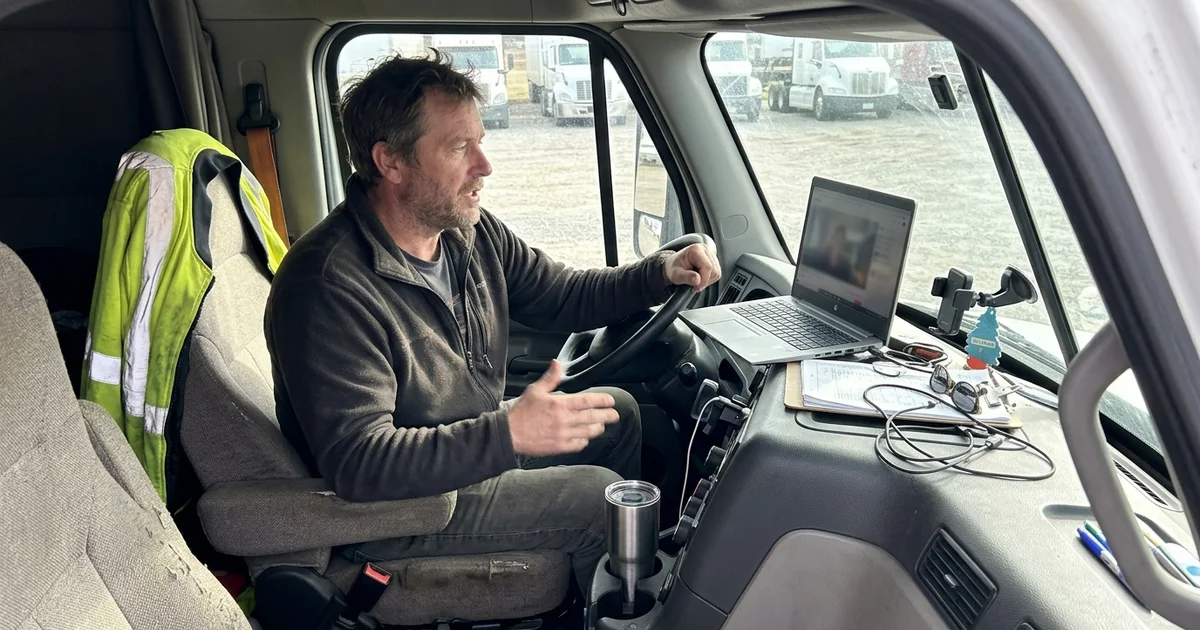 Owner on a video call from a truck cab with a laptop on the dash