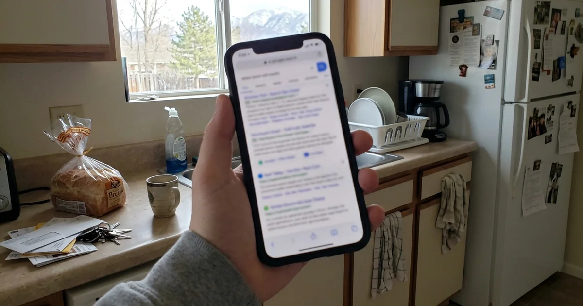 Phone showing blurred search ads at the top of a results page