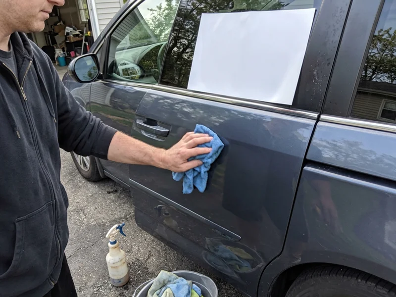 Wiping a car door before placing a magnet