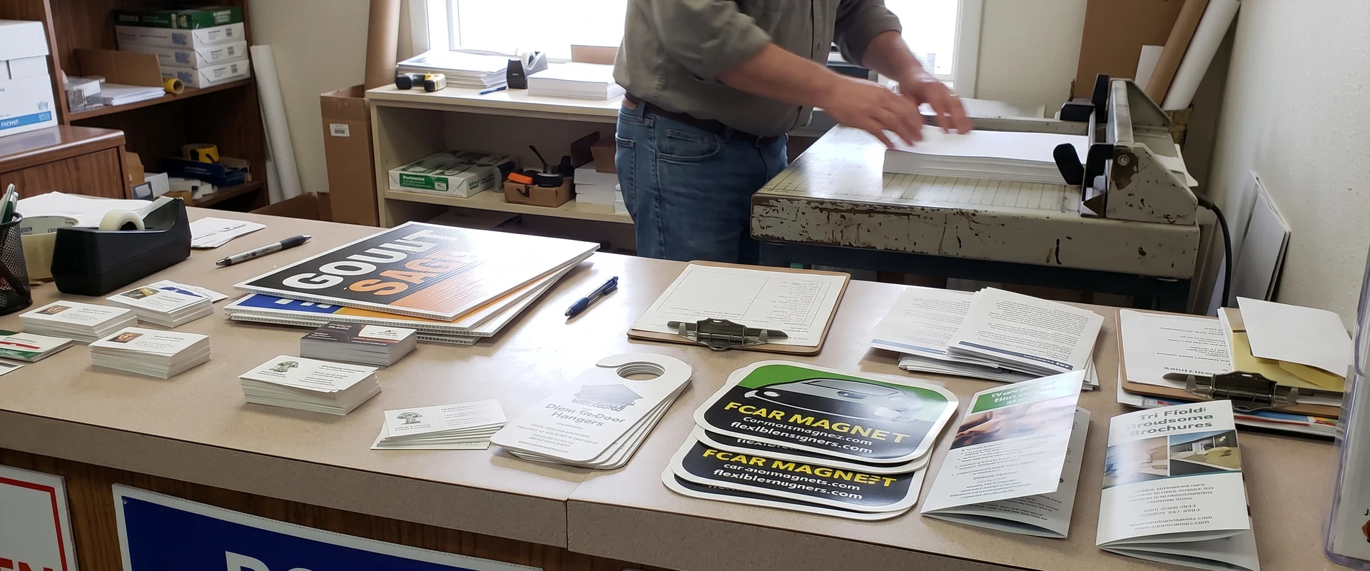 Print shop counter with business cards, yard signs, door hangers and brochures