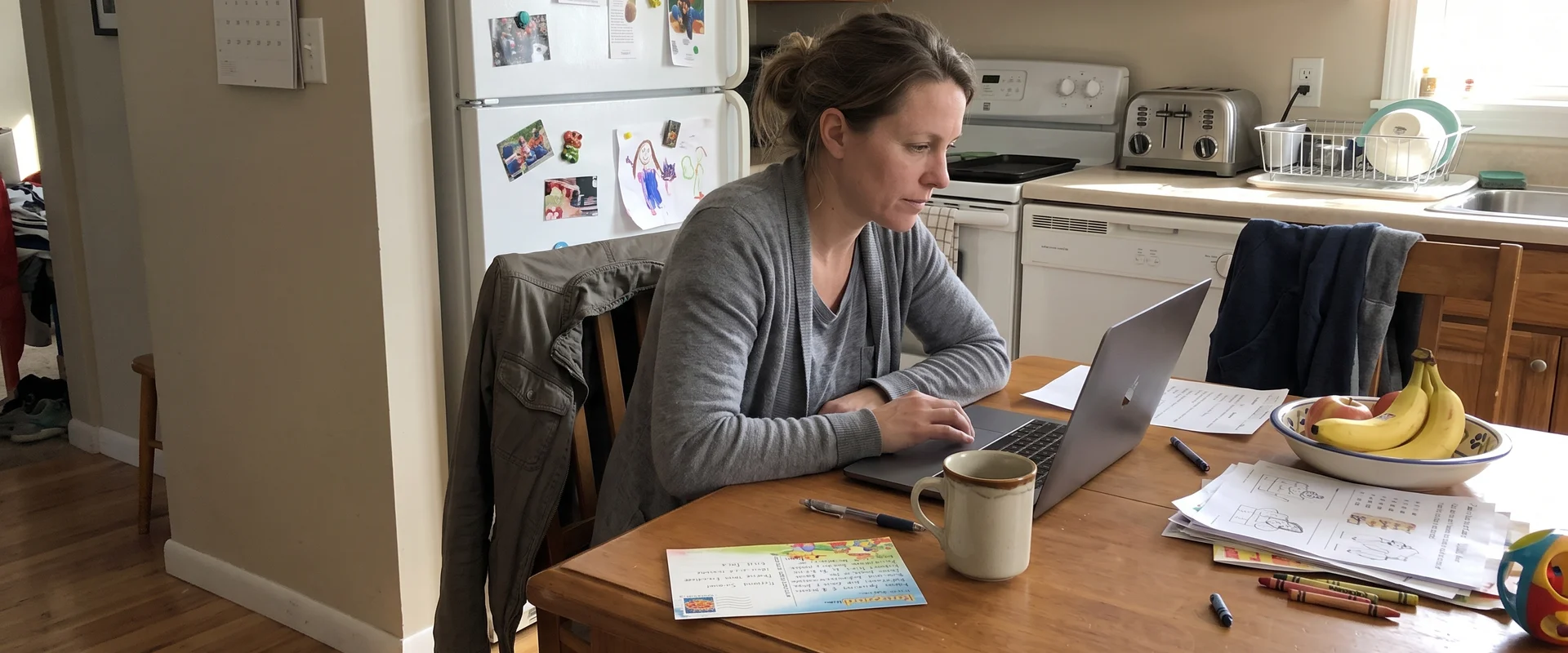 Business owner reading a guide on a laptop at a kitchen table