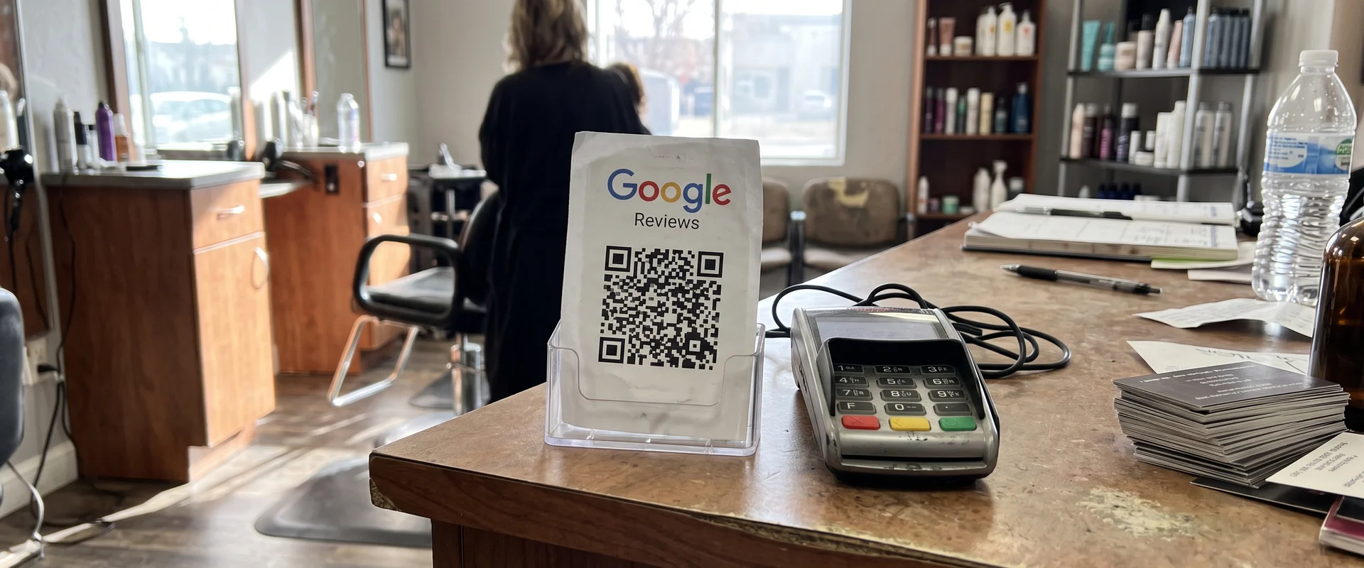 Google review QR card standing on a salon counter