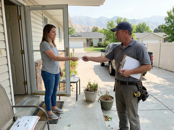 Handing a business card to a homeowner