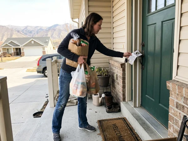 Homeowner finding a door hanger at the front door