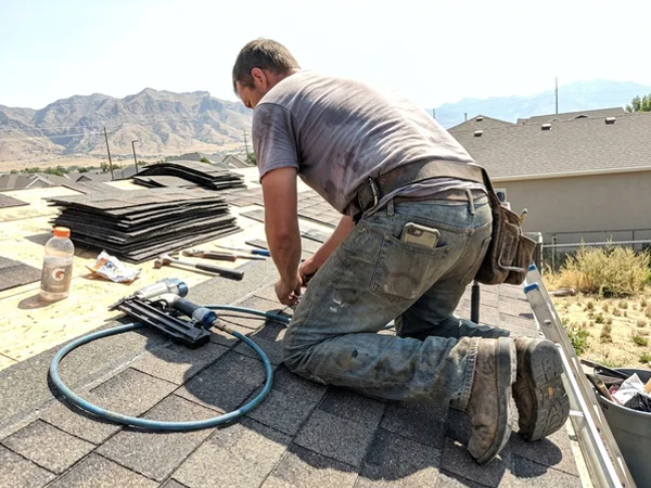 Roofer on a job with a phone ringing