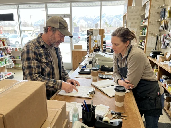 Owners comparing notes at a shop counter